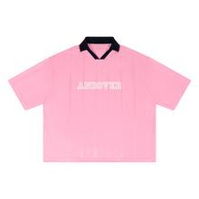 Load image into Gallery viewer, A pink short-sleeve polo shirt with a black collar and the word 'ANDOVER' printed in white across the chest, shown flat against a white background.