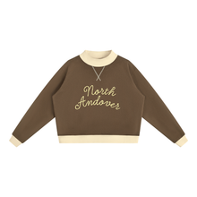 Load image into Gallery viewer, A brown long-sleeve crewneck sweatshirt with cream ribbed collar, cuffs, and hem, featuring 'North Andover' embroidered in cream script across the chest.