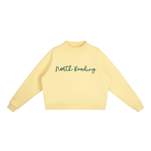 Load image into Gallery viewer, A pale yellow long-sleeve crewneck sweatshirt with 'North Reading' embroidered in dark green cursive across the chest, displayed flat against a solid white background.