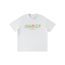 Load image into Gallery viewer, A white short-sleeve crewneck t-shirt featuring the word 'ANDOVER' in colorful, playful letters with a small feather detail inside the 'A', and 'MASSACHUSETTS' printed underneath in a light brown font.
